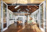 Tasked by John Powers and Jennifer Bostic with renovating a run-down cottage that was never meant to be lived in year round, Otto Ruano of Lead Studios transformed the space while keeping as much of it intact as possible. Potence lamps by Jean Prouvé illuminate the kitchen and living area. The bifold doors are by Loewen.