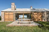 A wooden picnic table is located off one end of the living room, creating a tranquil setting to enjoy alfresco dining while soaking up the sunshine.
