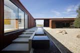 A monolithic opening in the facade provides an entrance from the exterior into the courtyard. The property's extensive landscaping was completed by George Girvin, with outdoor lighting by designer Pamela Burton.