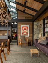 "It was our job to hold on to the spirit of these buildings. They worked so well with the site and the views, so the project was really about exercising restraint,” says architect Brian Court. In the guesthouse, Gulassa wired a wisteria branch preserved from the property into a chandelier. The armchair is by Jens Risom and the windows are by Unilux.
