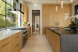 A section of the custom cabinetry in the kitchen features striking, half-circle bronze pulls. Noori chose the double Executive Chef sink by House of Rohl for its simple form and high performance.