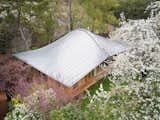 Barache describes the metal roof as essentially a deformed plane, placing an apple beneath a sheet of paper to demonstrate his point. He chose zinc for its malleability and the high level of the craftspeople who work with it.