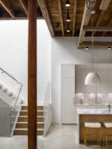 A white metal staircase leads up to the master bedroom.