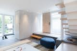 The exterior materials are carried inside to a slatted entryway that conceals a utility unit and closet.