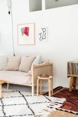 The Boho Natural Daybed by CB2 is piled with Parachute pillows and creates a cozy nest in the living room. The wall sconce is from France &amp; Son.