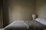 This bedroom's monochromatic and moody green feels calming rather than oppressive.